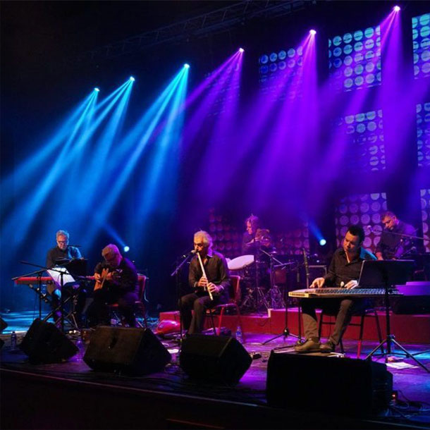 Omar Faruk Tekbilek & Ensemble in Concert on stage with colorful lights